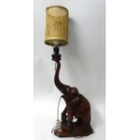 An Indian carved hardwood table lamp in the form of an elephant, (wood 56cm high)