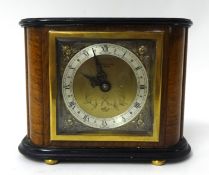 An Elliott mantle clock in walnut case, the square dial with gilt metal spandrels, on bun feet, with