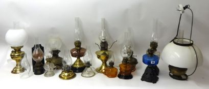 A collection of 14 assorted Victorian and later oil lamps including brass, coloured glass