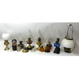 A collection of 14 assorted Victorian and later oil lamps including brass, coloured glass
