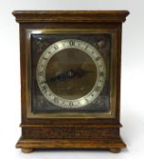 An Elliott mantle clock in oak case, the square dial with gilt metal spandrels, on bun feet, with