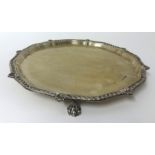 A silver salver with gadrooned border and claw feet, approx 16 oz