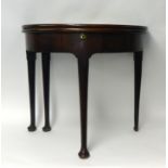 An 18th century mahogany fold over 'half moon' tea table, with swing back leg and pad feet (one