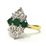 An emerald three stone and diamond cluster ring of lozenge shape, ring size N, 18ct gold