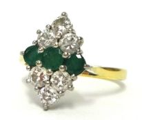 An emerald three stone and diamond cluster ring of lozenge shape, ring size N, 18ct gold