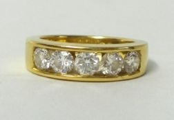 An 18ct yellow gold ring, channel set ring with five round cut diamonds, approx 1.00 carat total