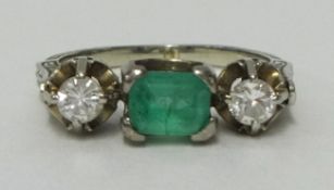 An antique emerald and diamond three stone ring size M set in white gold