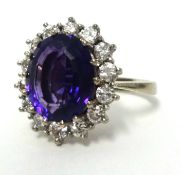 An 18ct white gold amethyst and diamond cluster ring set in unhallmarked white metal stamped 18