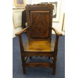 A carved oak open armchair in stressed oak in the antique style