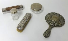 A silver and chased back dressing table mirror, silver backed clothes brush, two silver topped