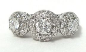 A near new three stone diamond ring set within a halo design stamped 18ct, white gold, ring size O