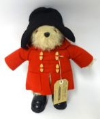 A Paddington Bear soft toy with red coat and label 40cm tall