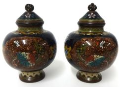 A pair of cloisonné jars and covers decorated with flowers and butterflies and a dragon chasing a