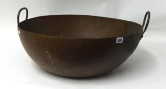A large copper twin handled bowl, 58cm diameter
