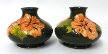 A pair of W Moorcroft vases decorated with pink poppies of squat form, 12cm high, one with paper