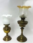 Two old brass oil lamps each with glass shade, tallest 66cm