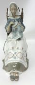 A Lladro figure modelled as a seated nun cross stitching, 27cm tall