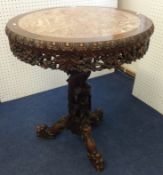 Chinese style carved rosewood pedestal table having circular top measuring 72cm diameter with pink