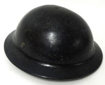 A WW I British tin helmet with leather chin strap
