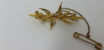An antique 15ct gold brooch decorated with two doves and set with seed pearl