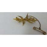 An antique 15ct gold brooch decorated with two doves and set with seed pearl