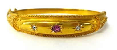 An antique 15ct gold bangle set with a ruby and two diamonds in possibly the original box, 11.6g