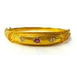 An antique 15ct gold bangle set with a ruby and two diamonds in possibly the original box, 11.6g