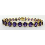 A fine amethyst and diamond bracelet set with approximately twenty five stones, 19cm long.