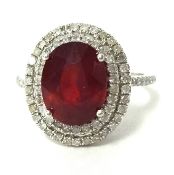 A ruby and diamond cluster ring set with further diamonds to the shoulders in 14K white gold.