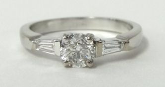 A near new Ladies three stone diamond ring featuring a central three brilliant cut diamond in four