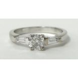 A near new Ladies three stone diamond ring featuring a central three brilliant cut diamond in four