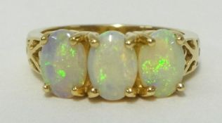 An opal three stone ring set in 14K yellow gold, ring size N.