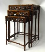 Nest of three carved Chinese rosewood tables with faux bamboo legs.