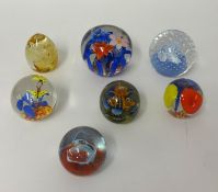 Seven assorted decorative paperweights.
