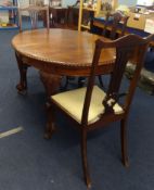 A mahogany extending dining table with two extension leaves with claw and ball feet t/w set of six