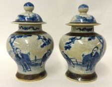 A pair of Chinese crackle glazed vases with covers, 27cm tall.