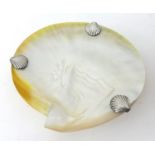 A mother of pearl shell dish with silver plated scallop mounts.