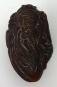 A small wood carving depicting a Chinese immortal, 7cm x 4cm.