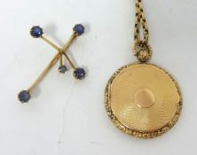 15ct gold cross set with blue gem stones, also a yellow metal circular locket pendant on link chain,