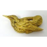 A yellow metal bird brooch.