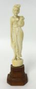 Small ivory carved figure of a Lady holding a water flask on wood base, 16cm.