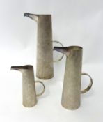 Set of three silver bark finish tapered cylinder jugs with elongated polished spouts, standing 23cm,