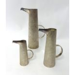 Set of three silver bark finish tapered cylinder jugs with elongated polished spouts, standing 23cm,