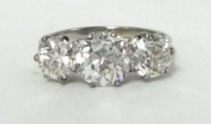 A fine three stone diamond Ring, claw set with old brilliant cut stones, the centre stone weighing