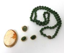 A jadeite bead Necklace, composed of 76 beads, a cabochon jade set Ring, a pair of Earclips, jade