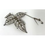 A silver set floral Brooch, set with white stones, of three leaf design, stamped 3CP, ENGLAND