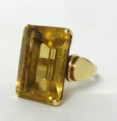 A 14kt gold and citrine dress Ring, claw set with a rectangular stone, size M.
