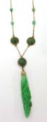 A gold and jade mounted Necklace, the carved floral drop to a trace link chain set with beads and