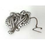 A silver set double clip Brooch, claw set with white stones, of scroll design, stamped 3CP,