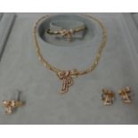 A gold and diamond set suite of jewellery, comprising a Necklace, a Bangle, a Ring and a pair of